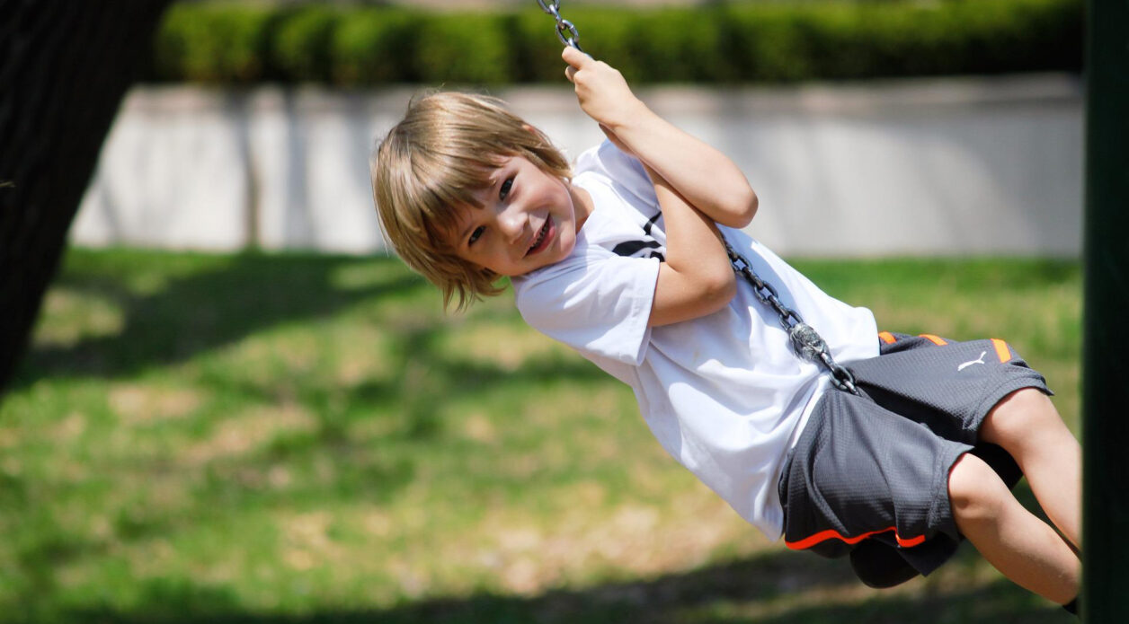 Child on tree swing in backyard